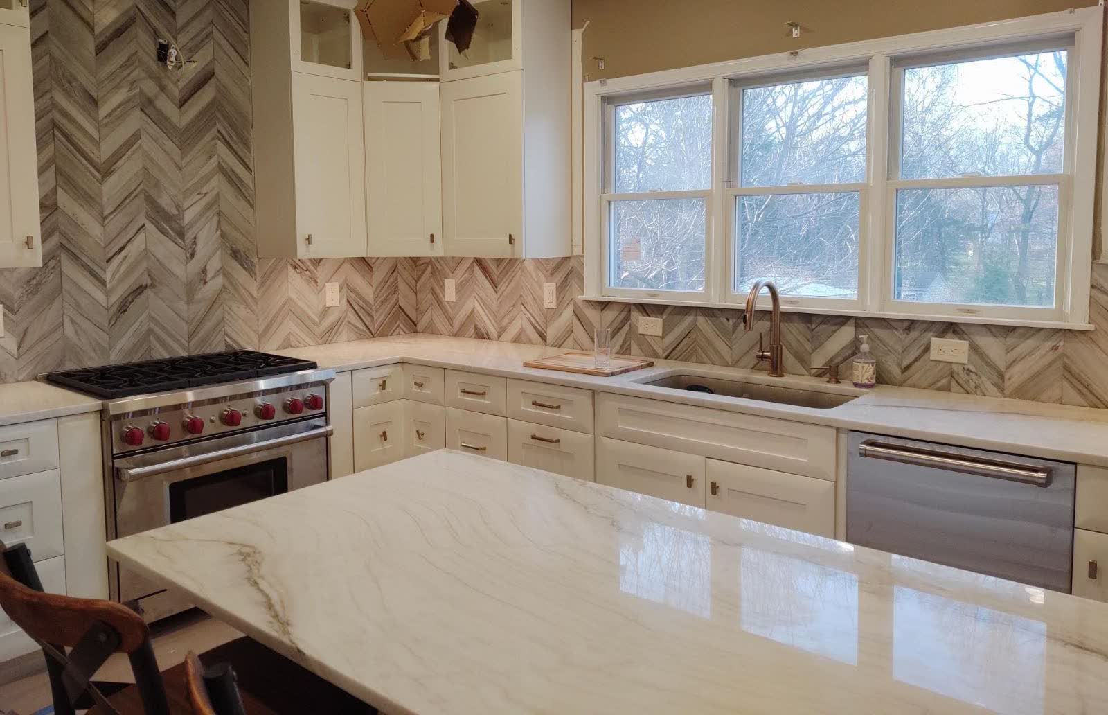 Chevron-pattern marble feature wall we installed, with the same layout discipline used on patterned floors